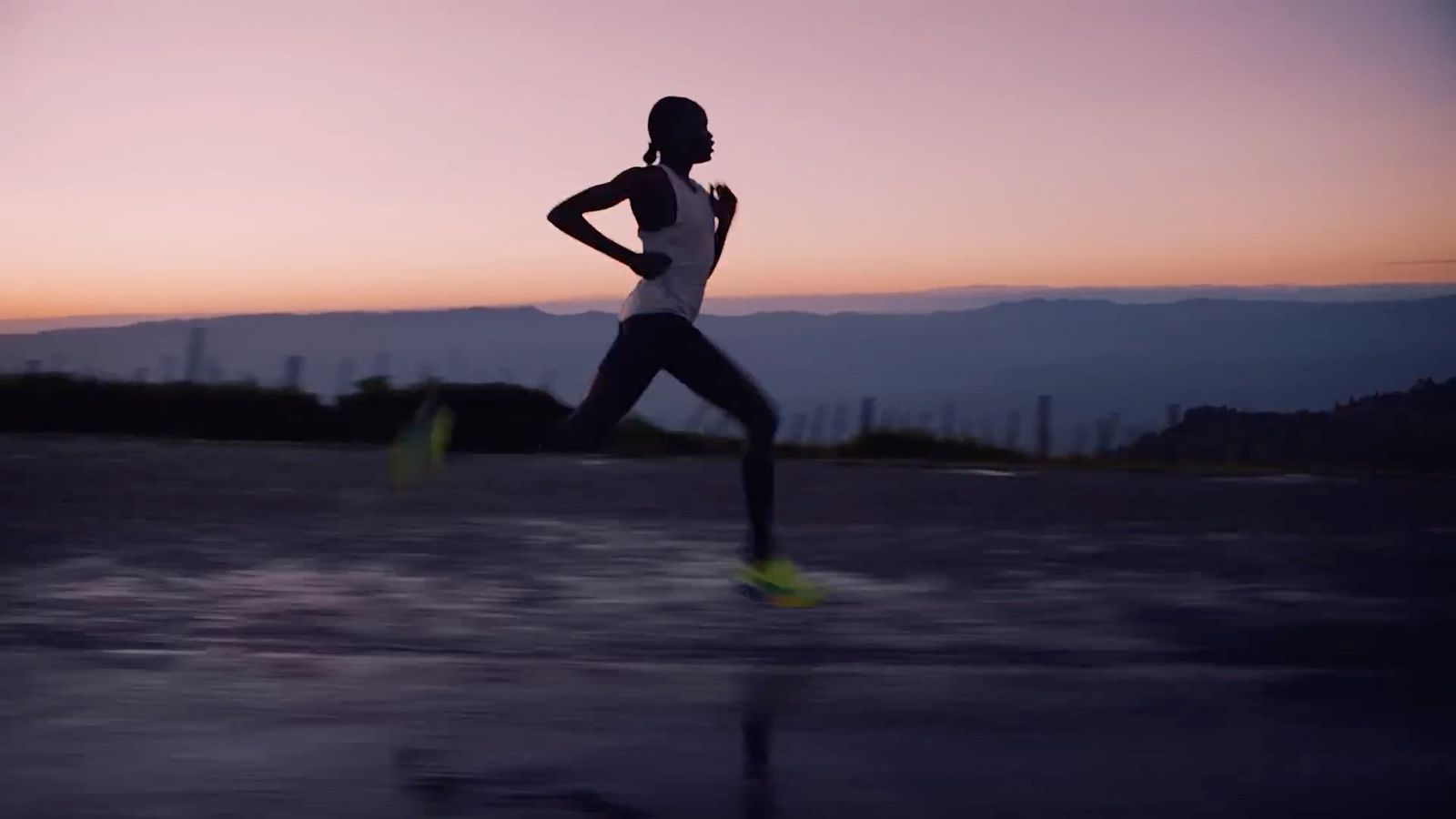 a woman running on a road at sunset