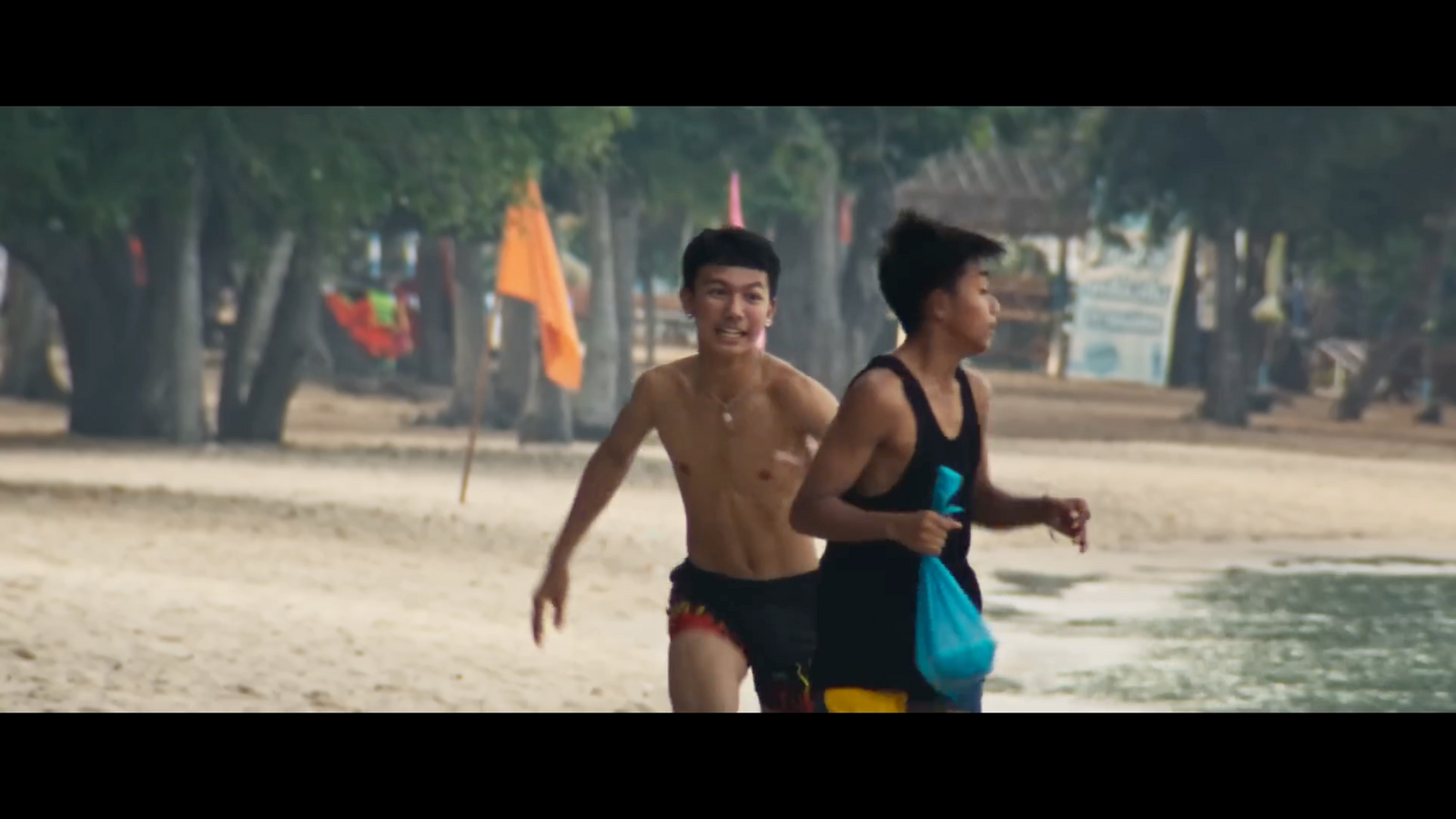 a man and a woman running on the beach