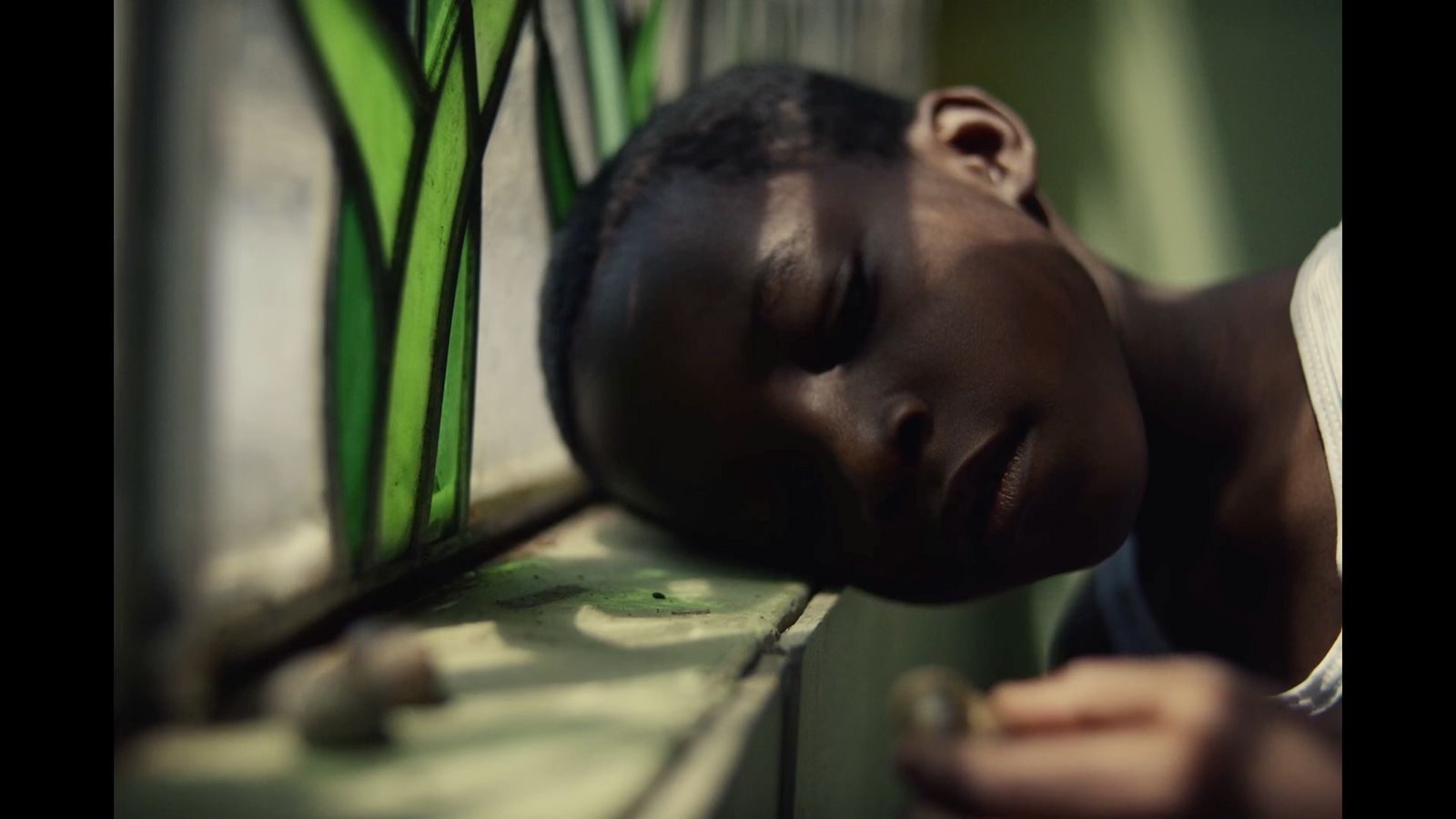 a young boy is sleeping on a window sill