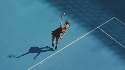 a person on a court with a tennis racket