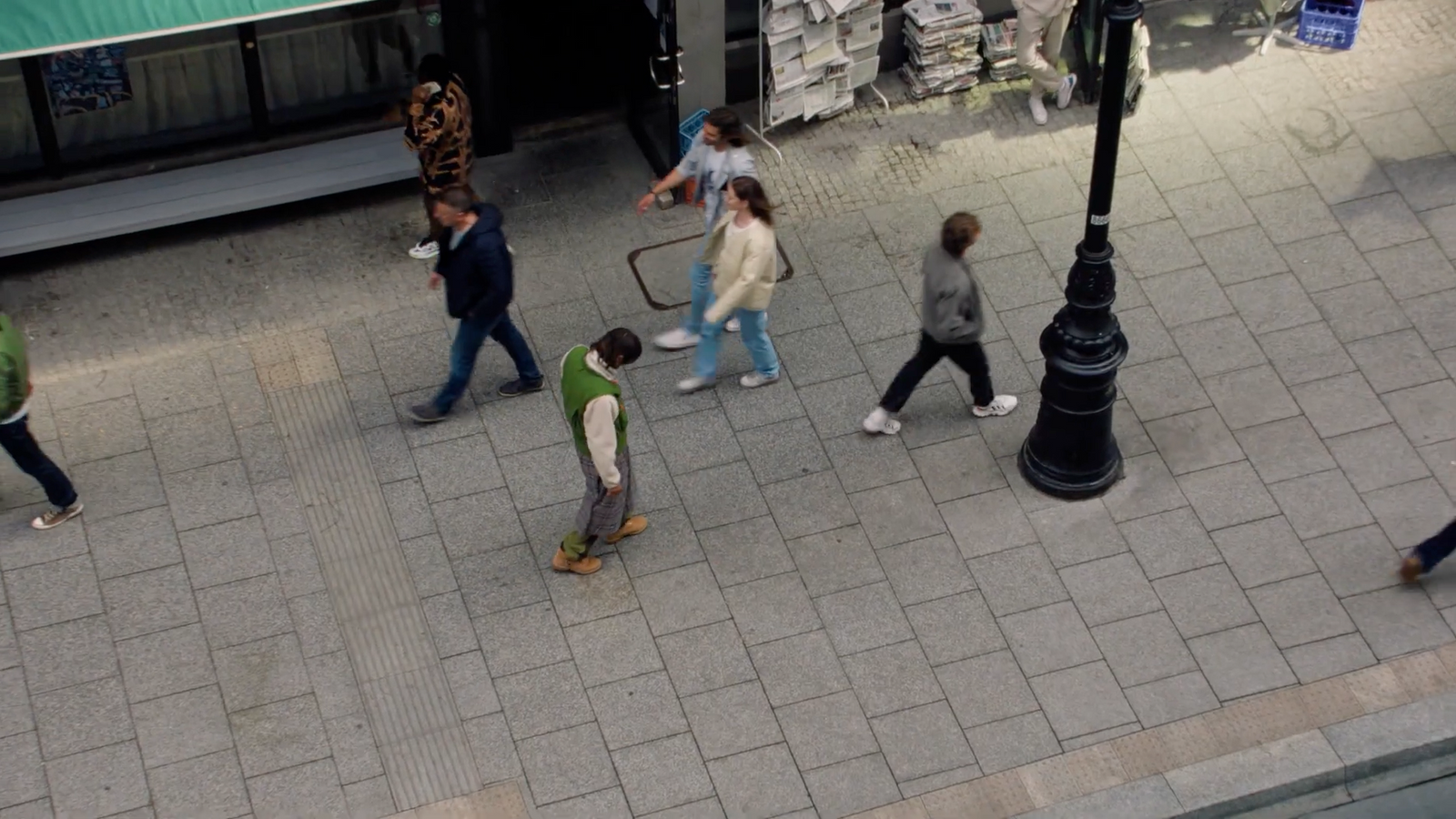 a group of people walking down a sidewalk