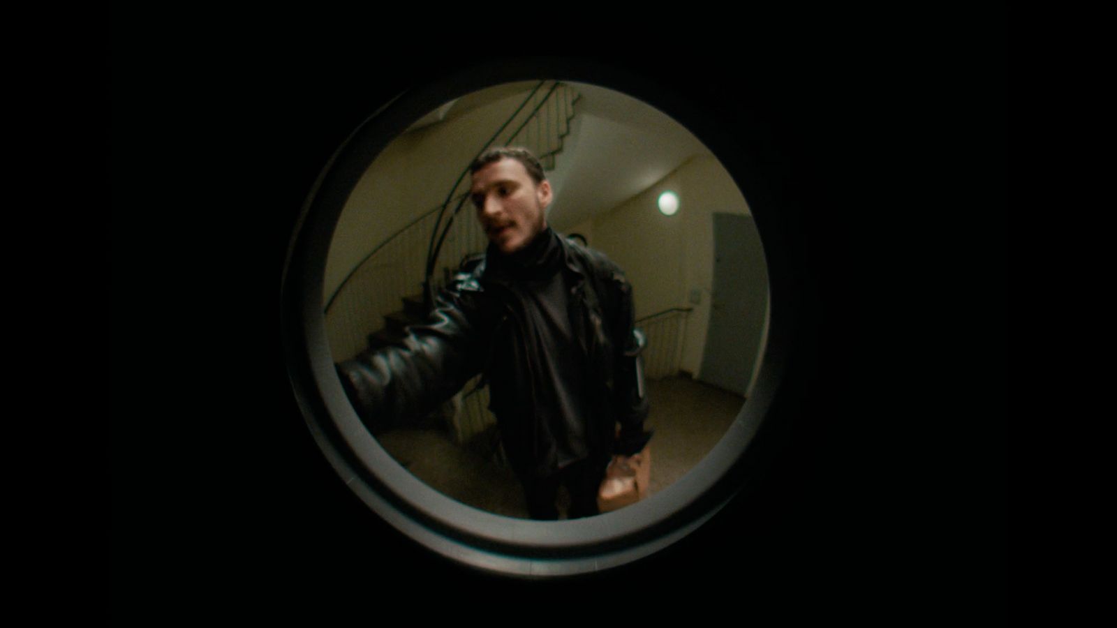 a man in a black leather jacket is taking a selfie