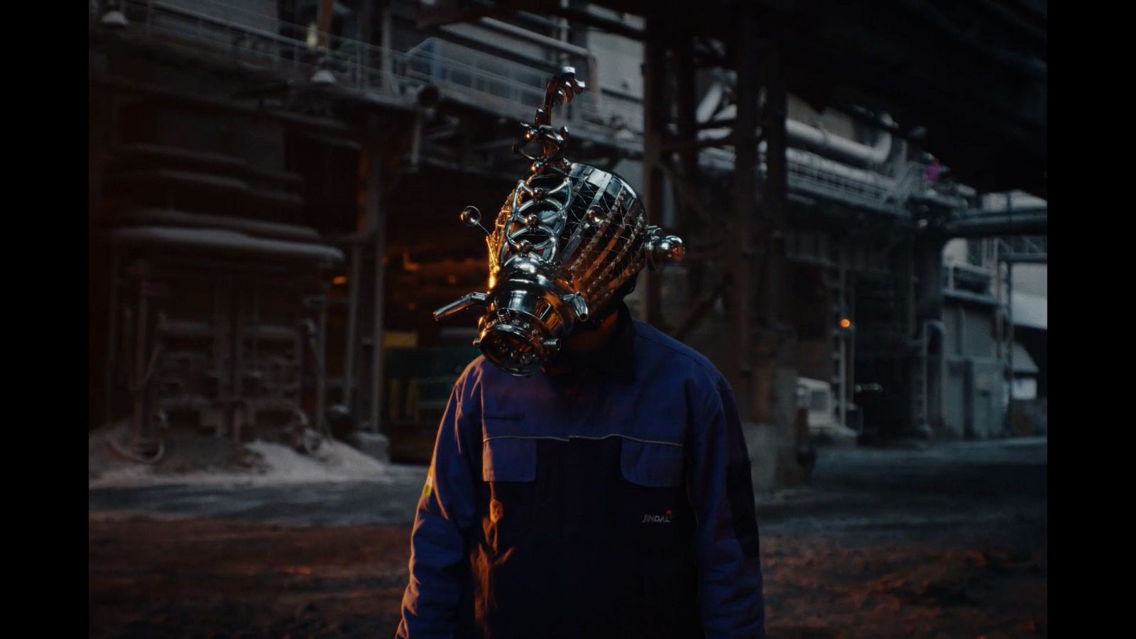 a man wearing a robot mask standing in front of a building