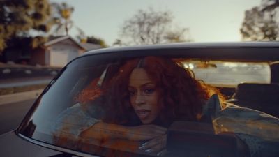 a woman with red hair sitting in a car