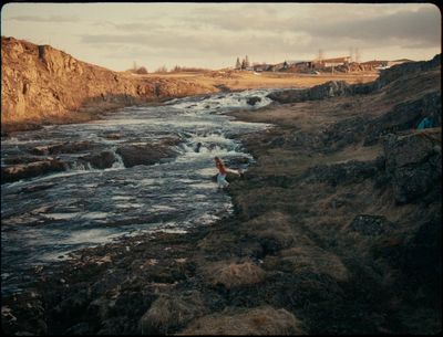 a person standing in a river with a surfboard