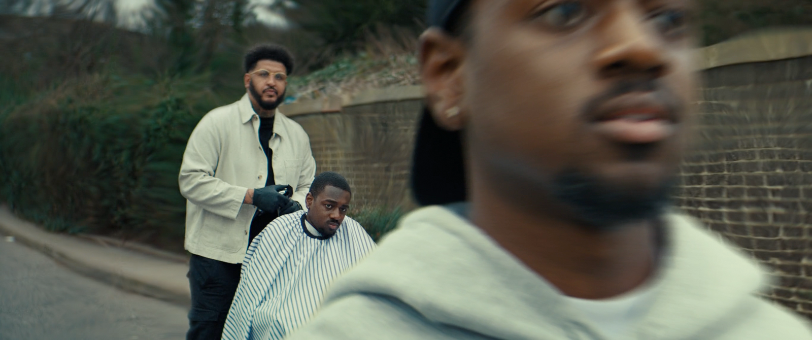 a man getting his hair cut by another man