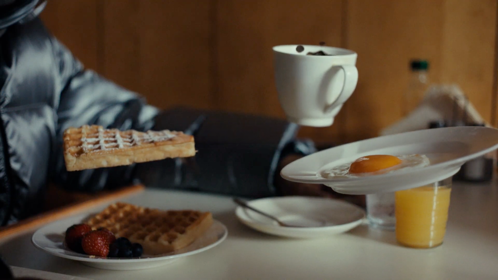 a breakfast of waffles, orange juice, and a cup of coffee