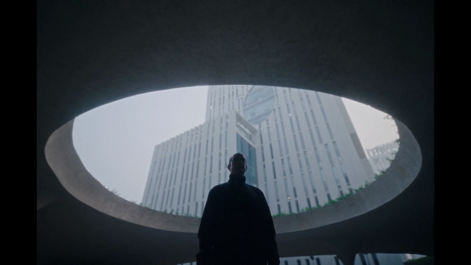 a man standing in front of a tall building