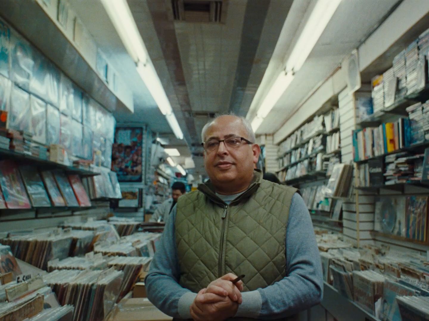 a man standing in a room full of cds