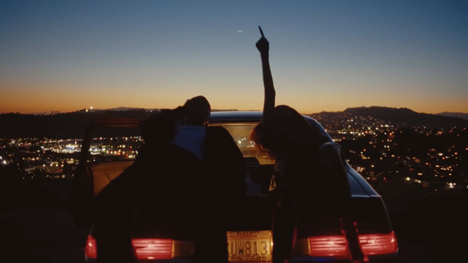 a couple of people that are standing in the back of a car