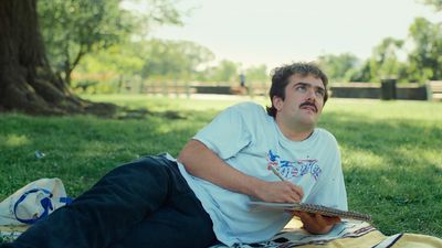 a man laying on a blanket in a park