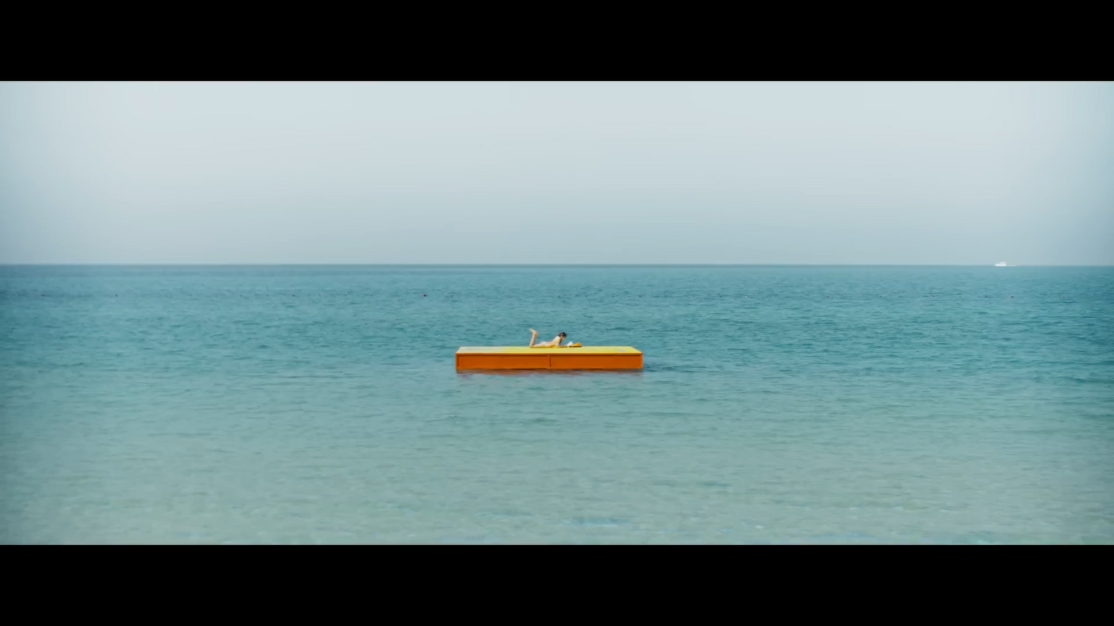 a yellow boat floating on top of a large body of water