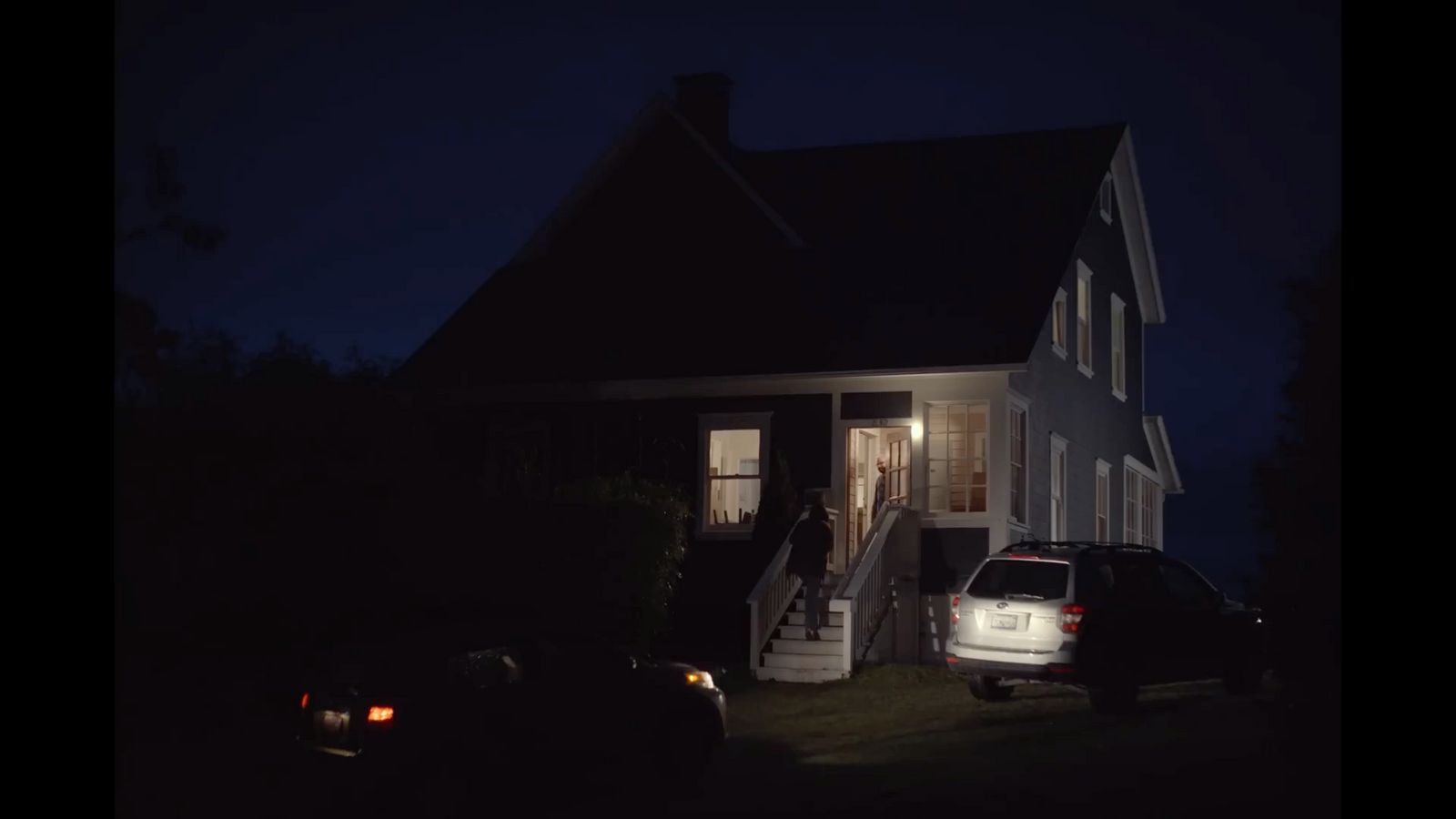 a car parked in front of a house at night