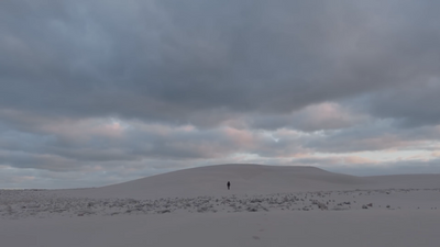 a lone person standing in the middle of a desert