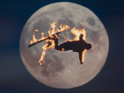 a person on a jet flying in front of a full moon