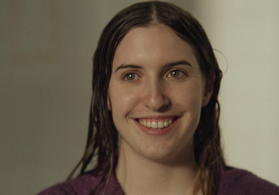 a woman with long hair smiling at the camera