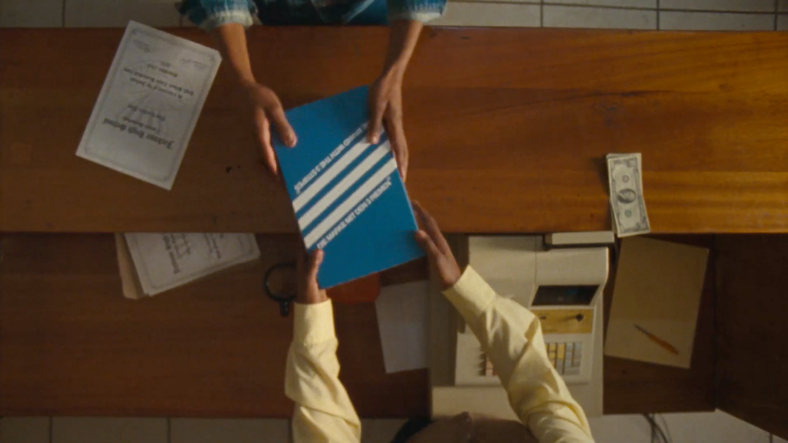 two people standing at a table holding a blue board