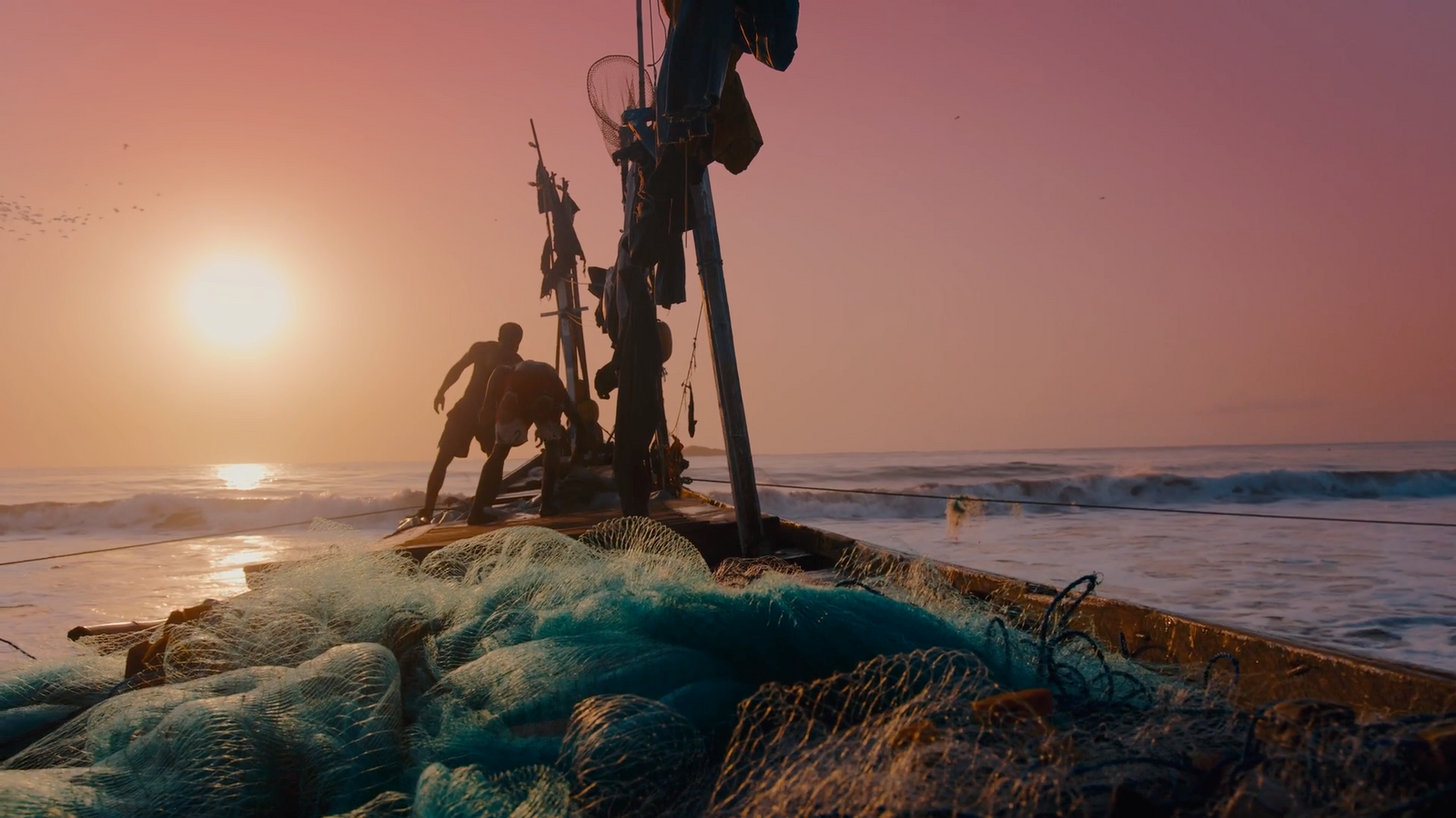 a man standing on top of a boat in the ocean