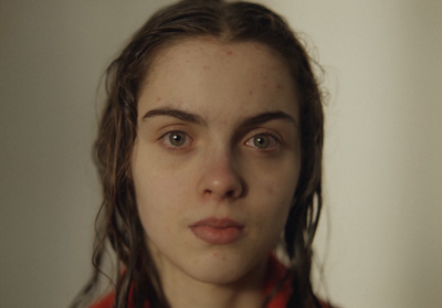 a woman with freckles on her face looking at the camera