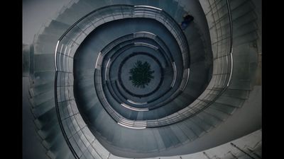 a man is walking down a spiral staircase