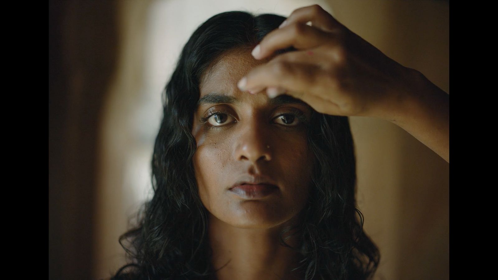 a close up of a person touching their forehead