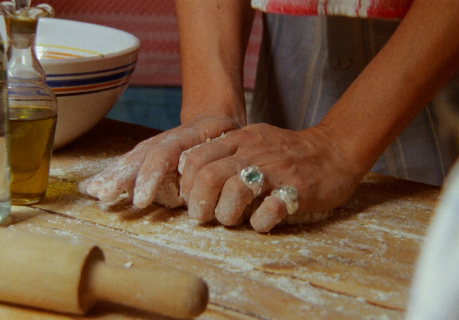 a person is kneading dough on a wooden table