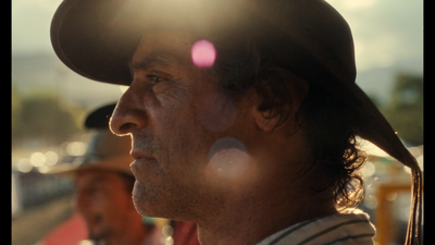 a man with a hat on his head looking off into the distance