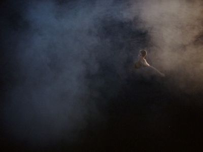 a person standing in the middle of a cloud of smoke