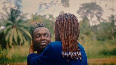 a man with dreadlocks standing next to a woman