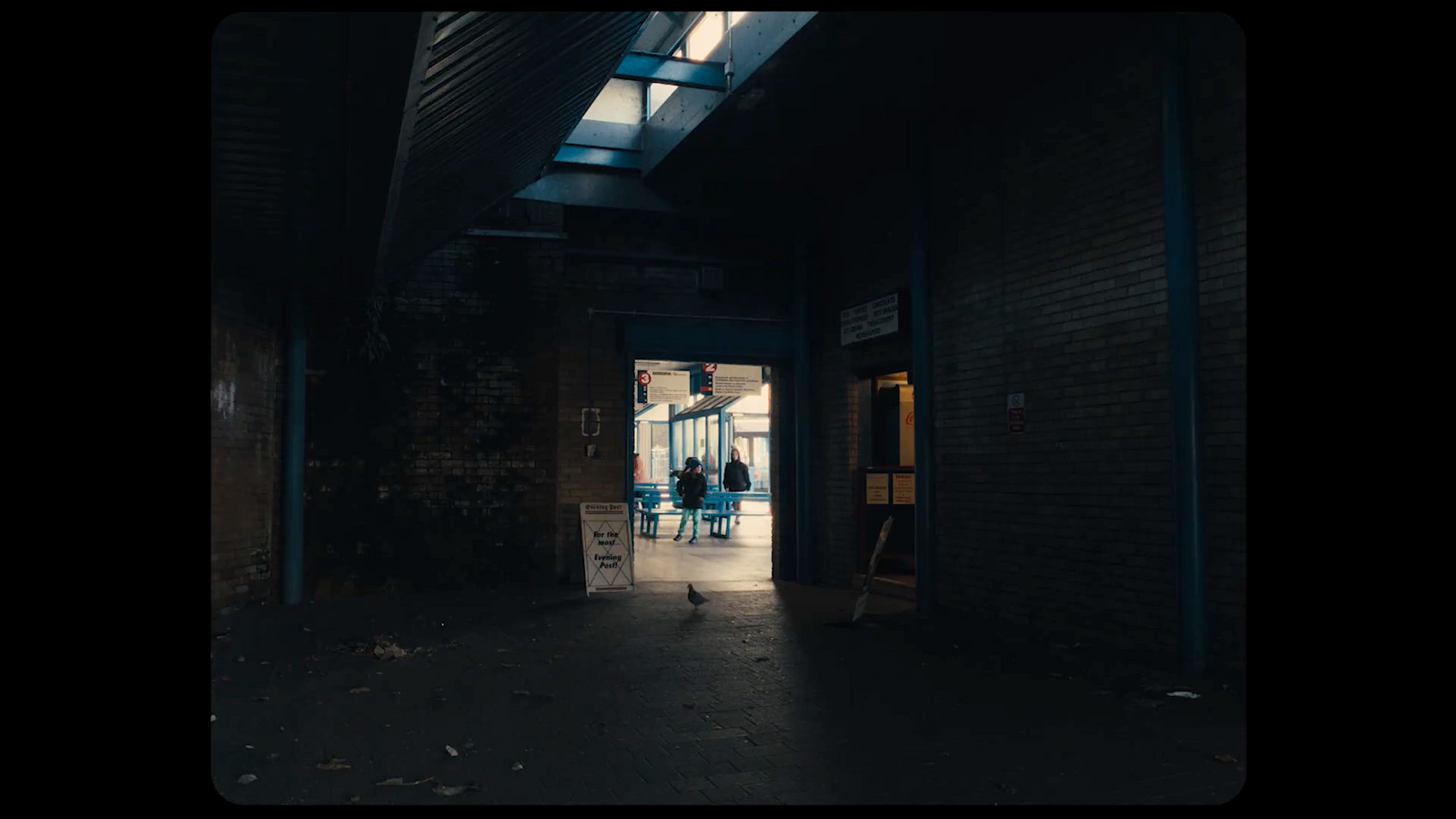 a dark hallway with a person standing in the doorway