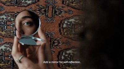 a person holding a mirror in front of their face