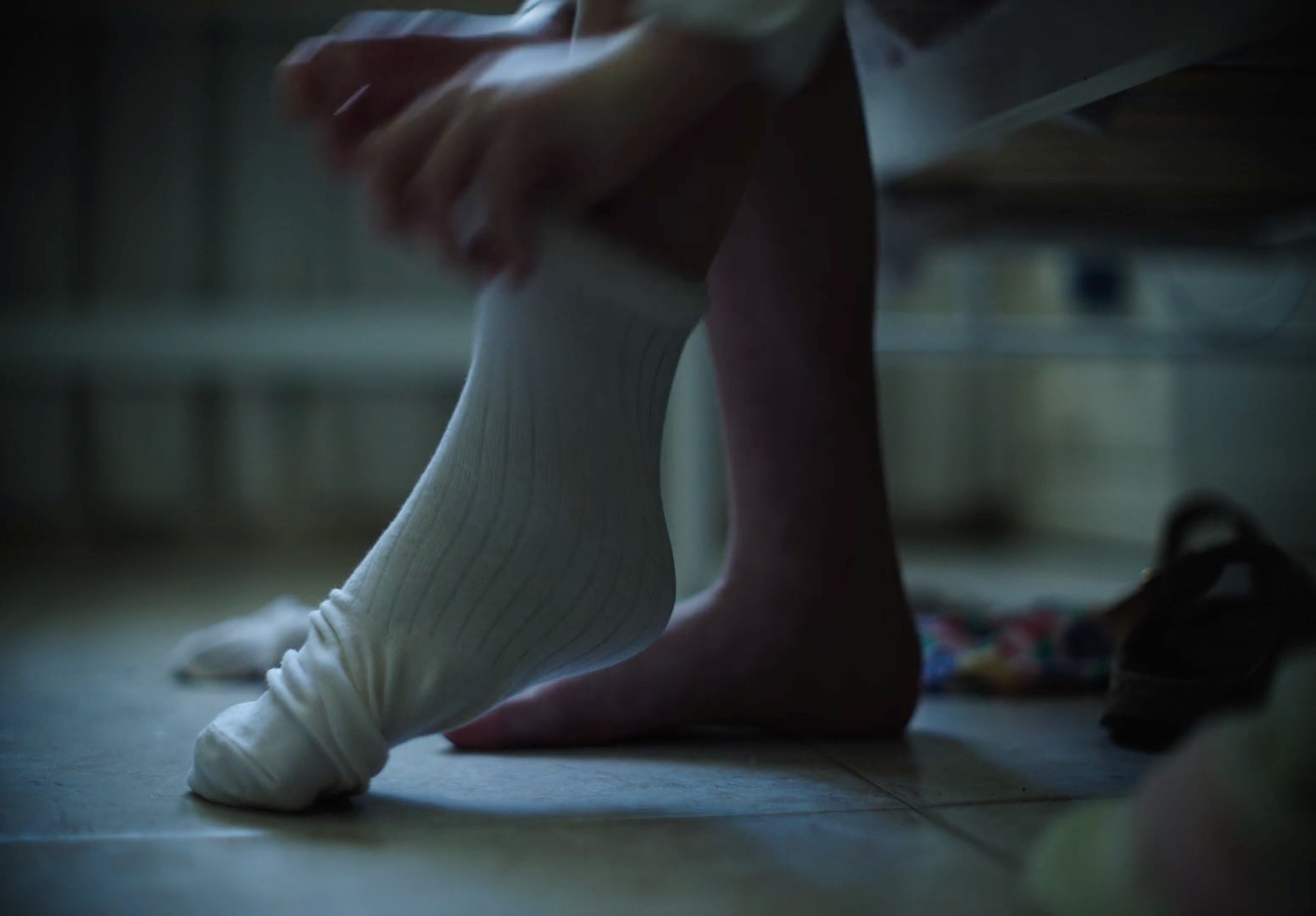 a person sitting on the floor with a pair of shoes