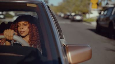 a woman driving a car down a street