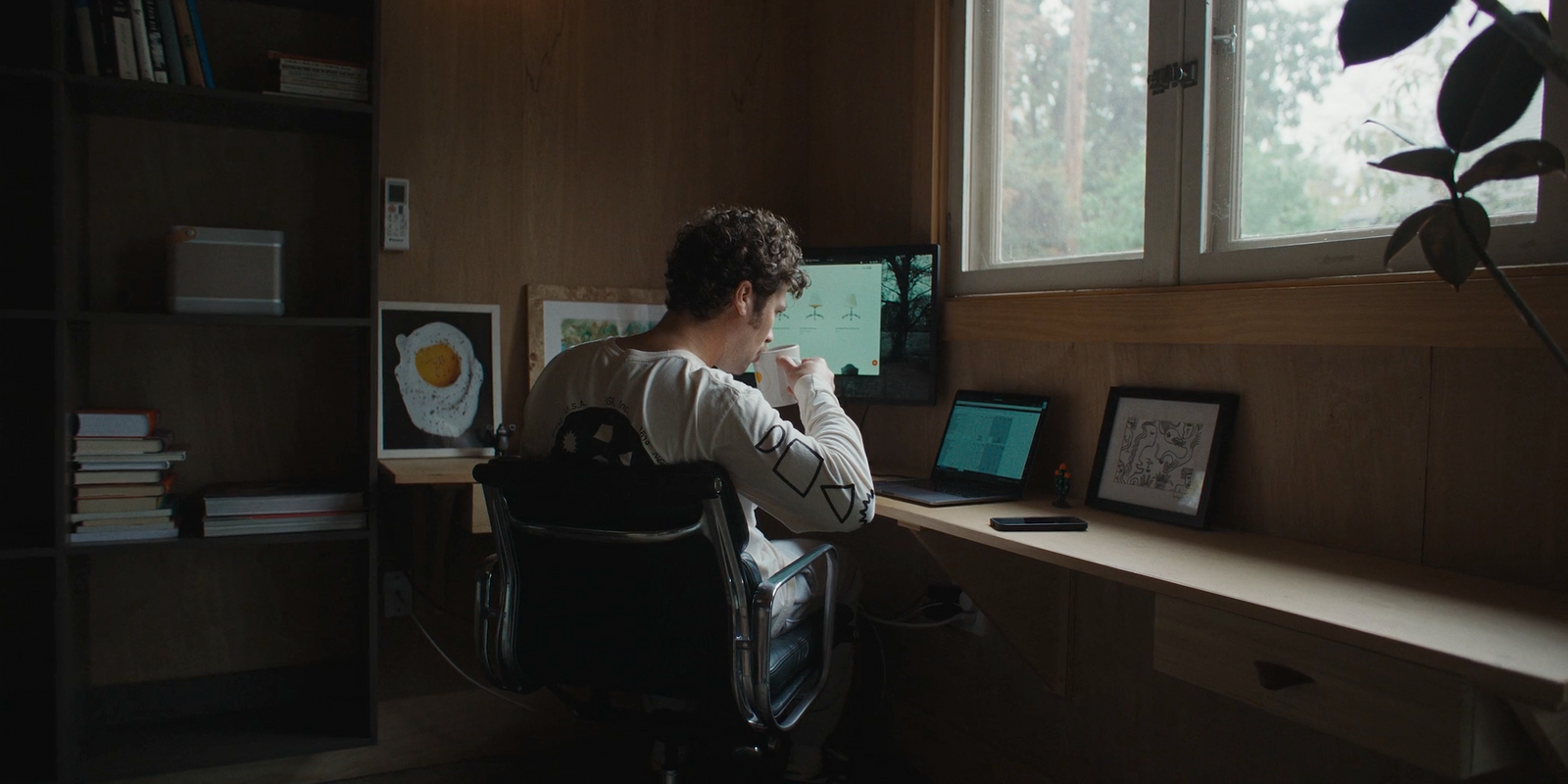 a man sitting at a desk in front of a laptop computer