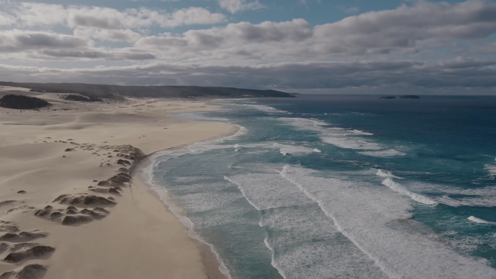 an aerial view of a sandy beach and ocean