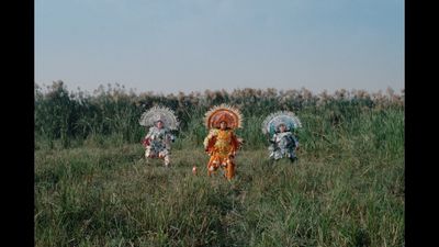 a group of people walking across a lush green field