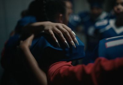 a close up of a person's hand on a football jersey