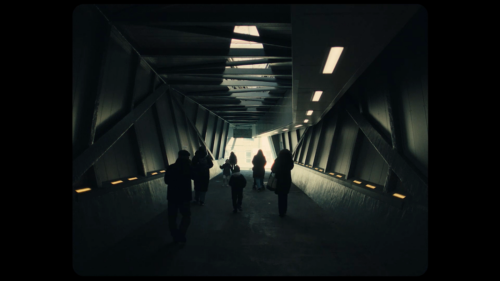 a group of people walking down a dark tunnel