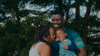 a man holding a baby and smiling at the camera