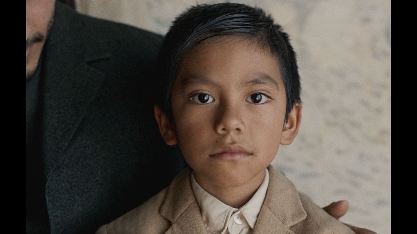 a young boy wearing a suit and tie