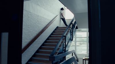 a person standing on a stair case next to a brick wall