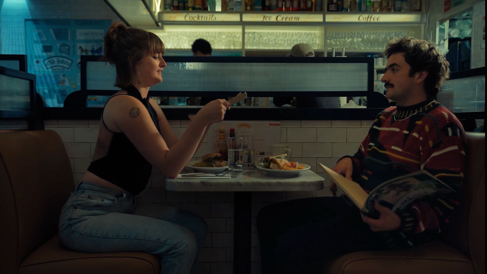 a man and a woman sitting at a table in a restaurant