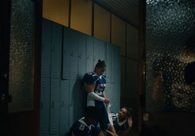 a group of people sitting on lockers in a locker room