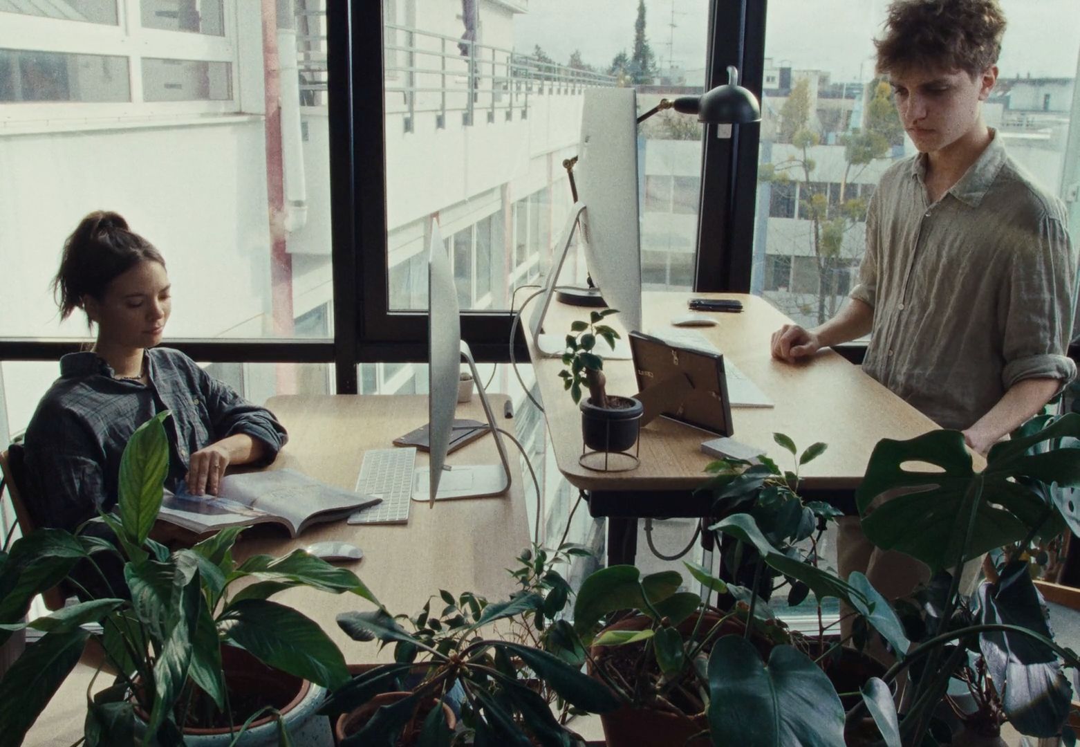 a couple of people sitting at a table with laptops