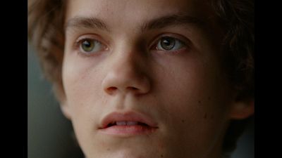 a close up of a young man with blue eyes