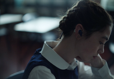 a woman wearing ear buds sitting in a chair