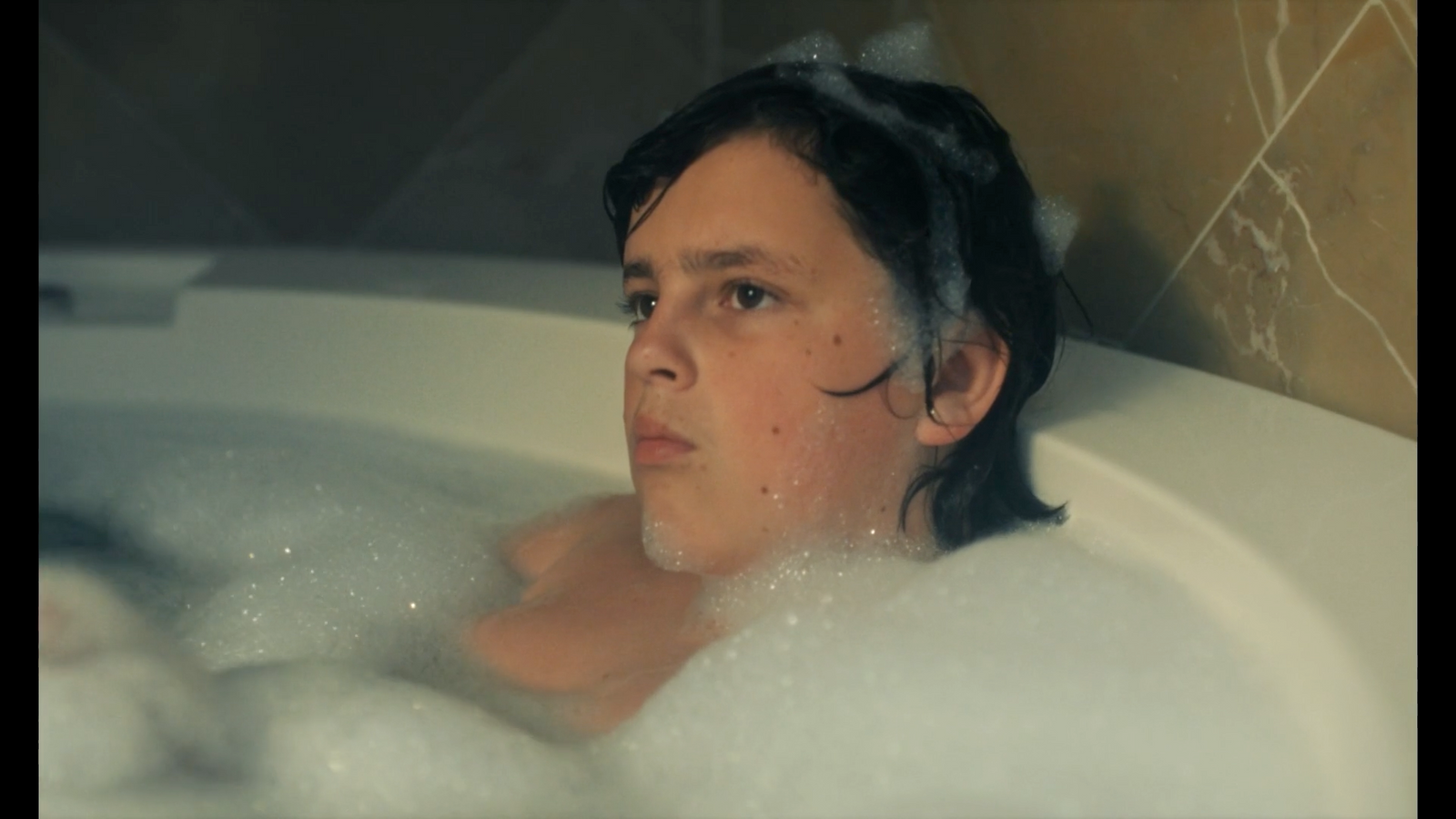 a woman in a bathtub with bubbles of water