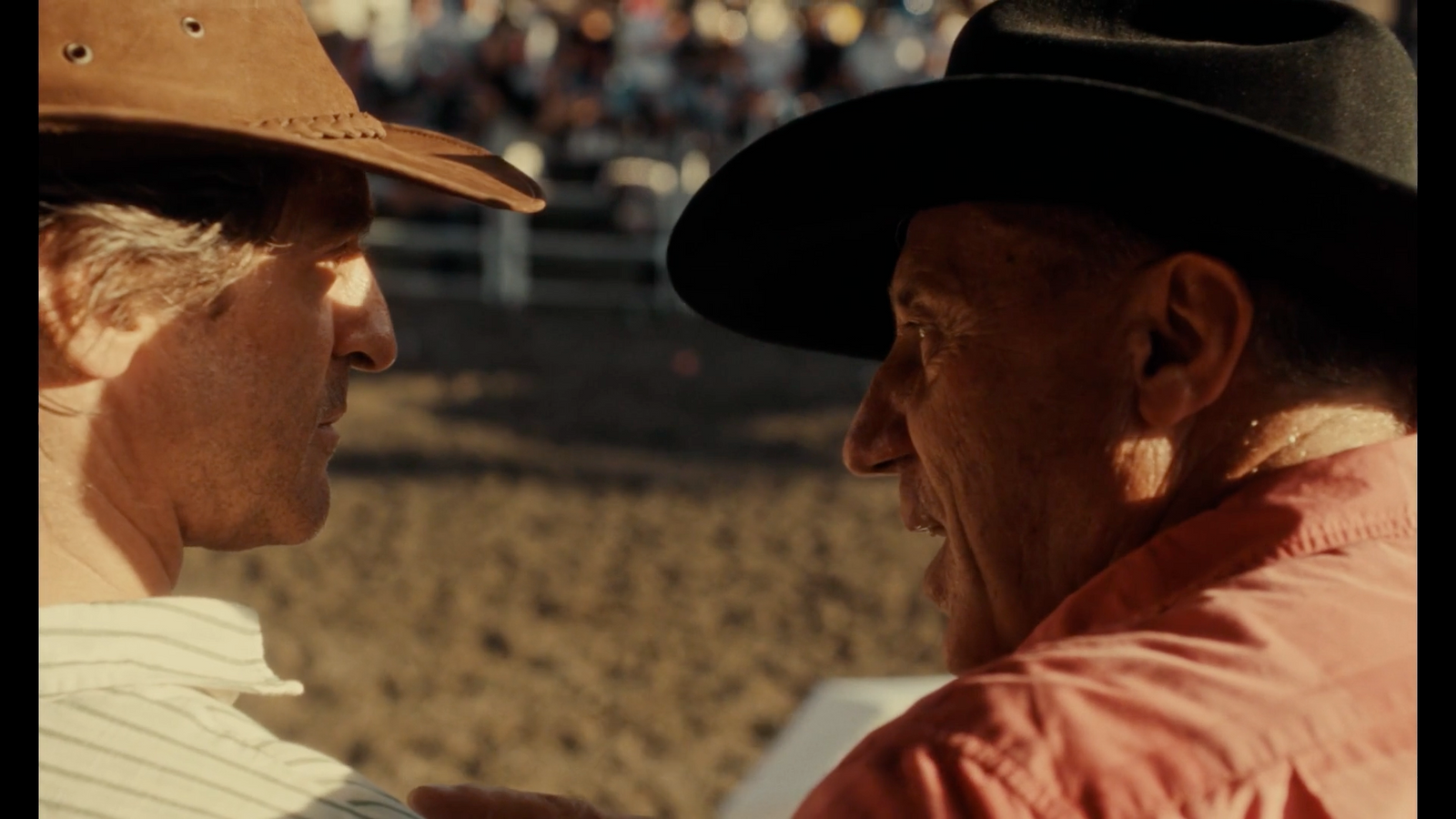 a man in a cowboy hat talking to another man