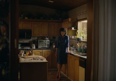 a woman standing in a kitchen next to a sink