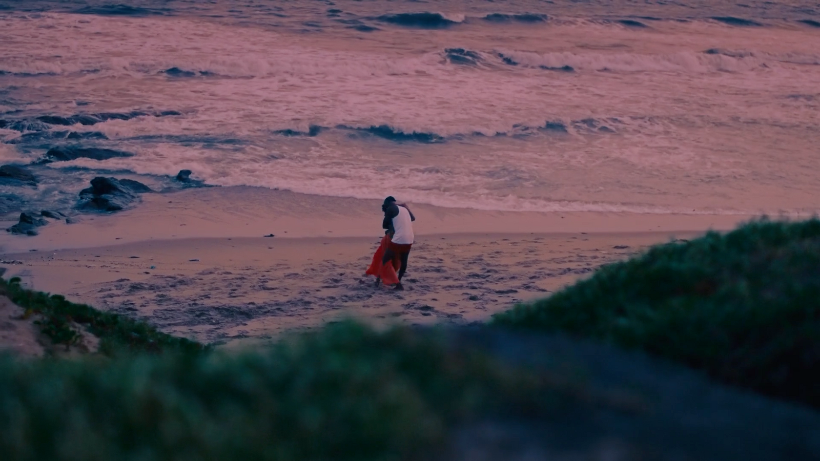 a woman standing on a beach next to the ocean